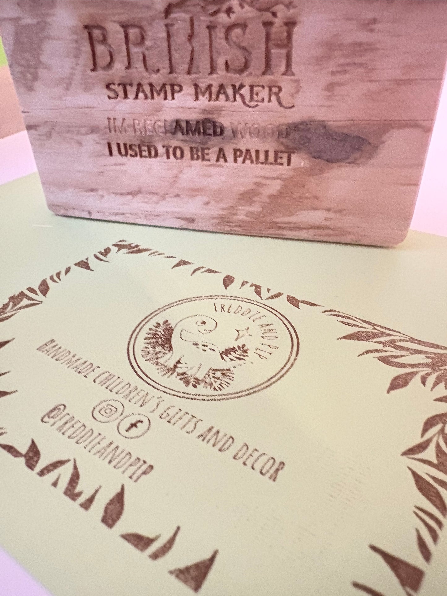 Freddie and pip business card rubber stamp stamped on a green card with British stamp maker stamp in the background this one use to be a pallet 