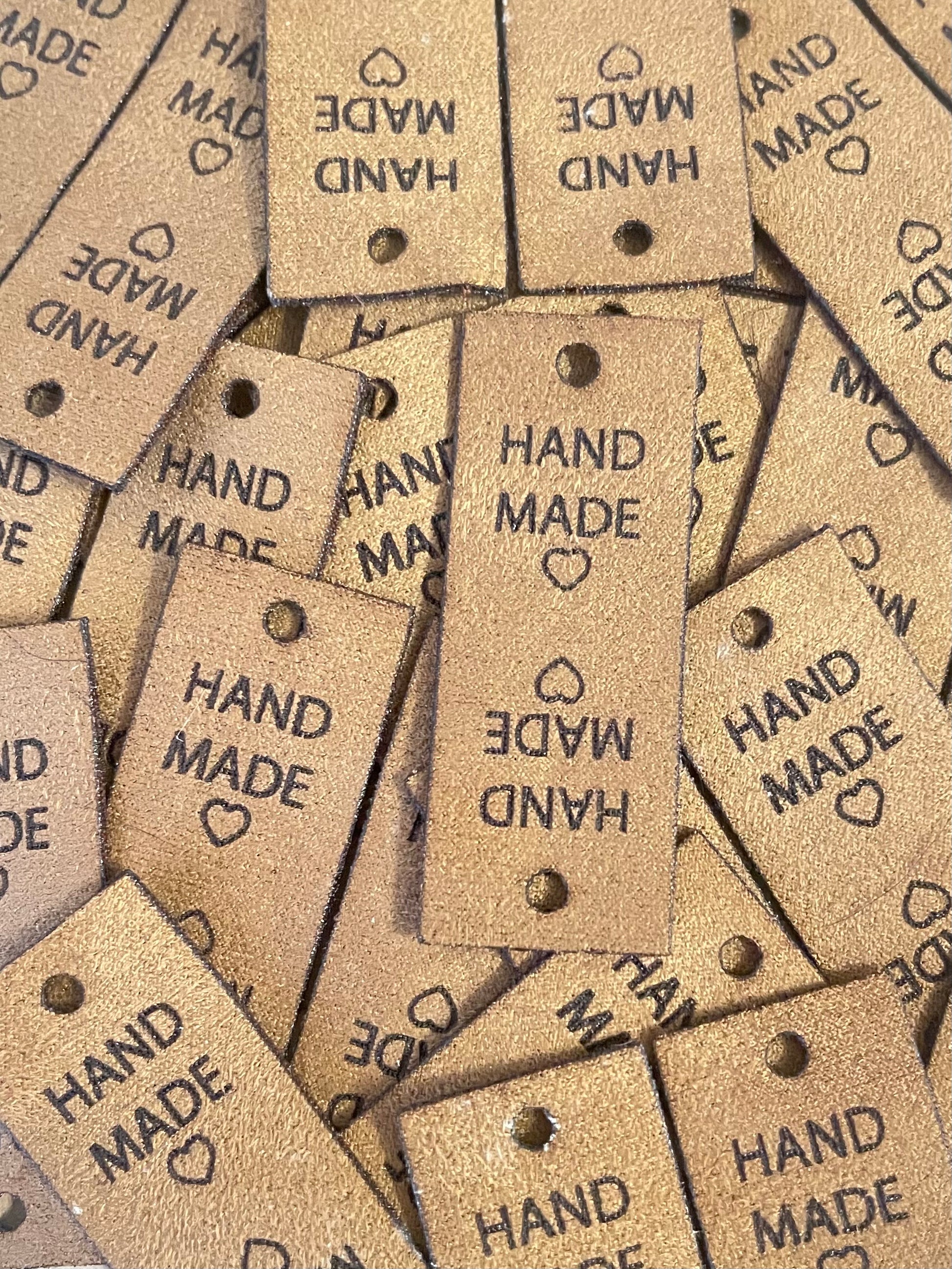 Brown faux suede tags with square edges and one hole for a rivet fastener. Featuring hand made text and a heart. The tag is foldable for use on crochet hats, scarfs, gloves, booties and knitted socks, beanies and more.