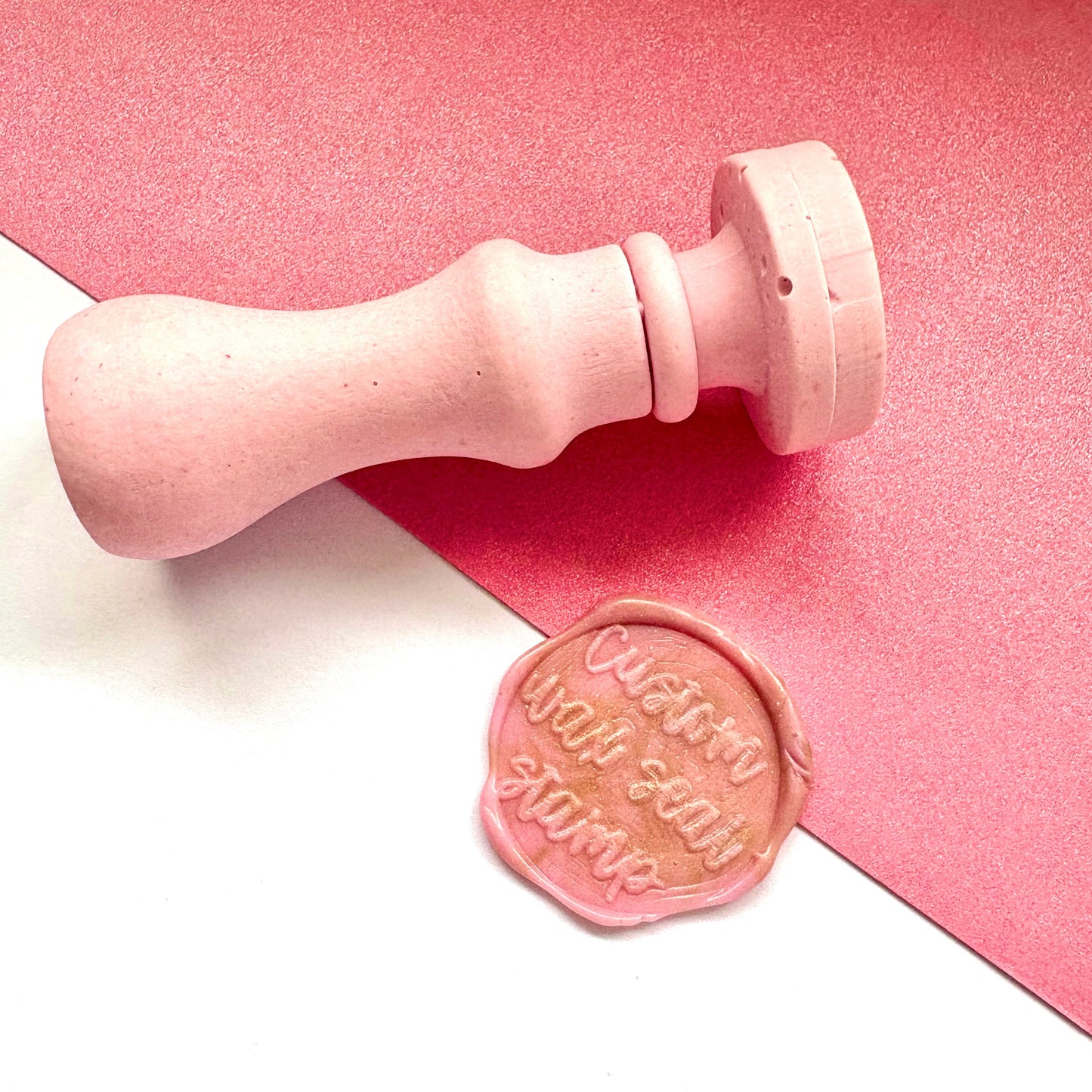 Pink handle custom wax seal stamp and pink wax seal impression with text.