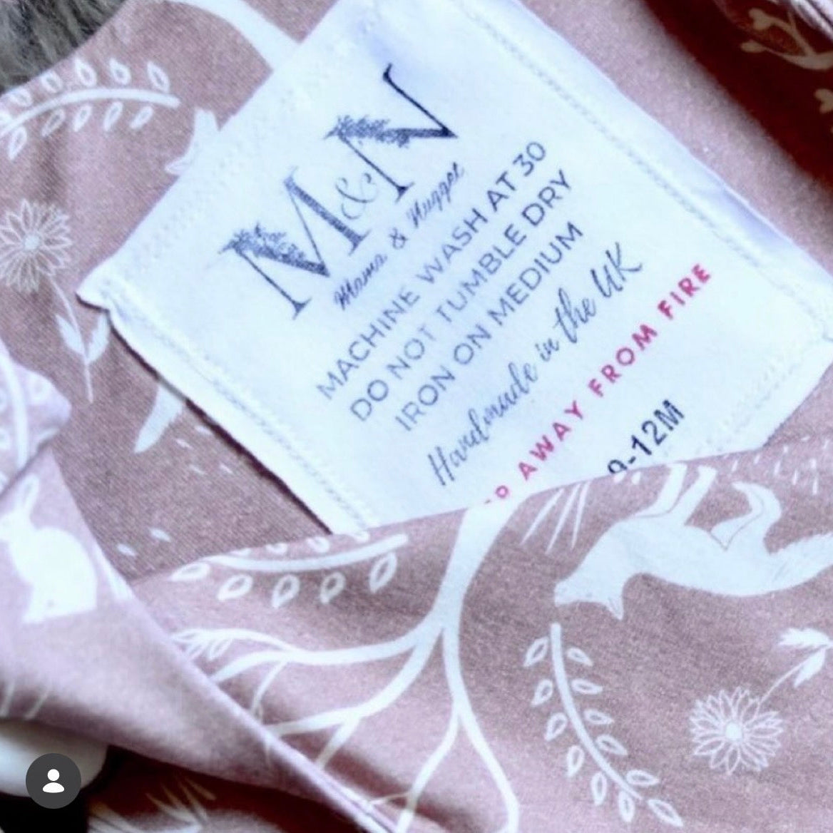 Fabric with a care label and white floral patterns on a brown background