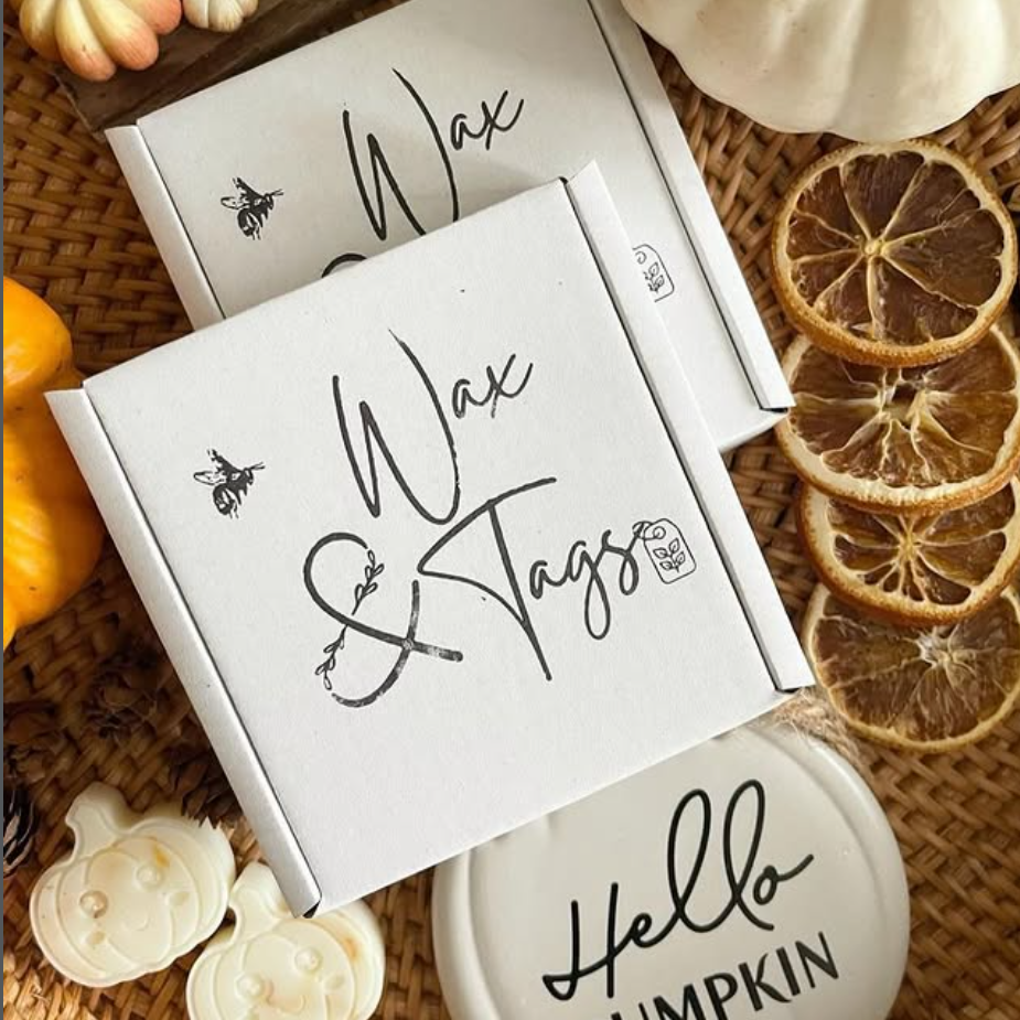 Wax and tags packaging with decorative pumpkins and oranges on a woven surface